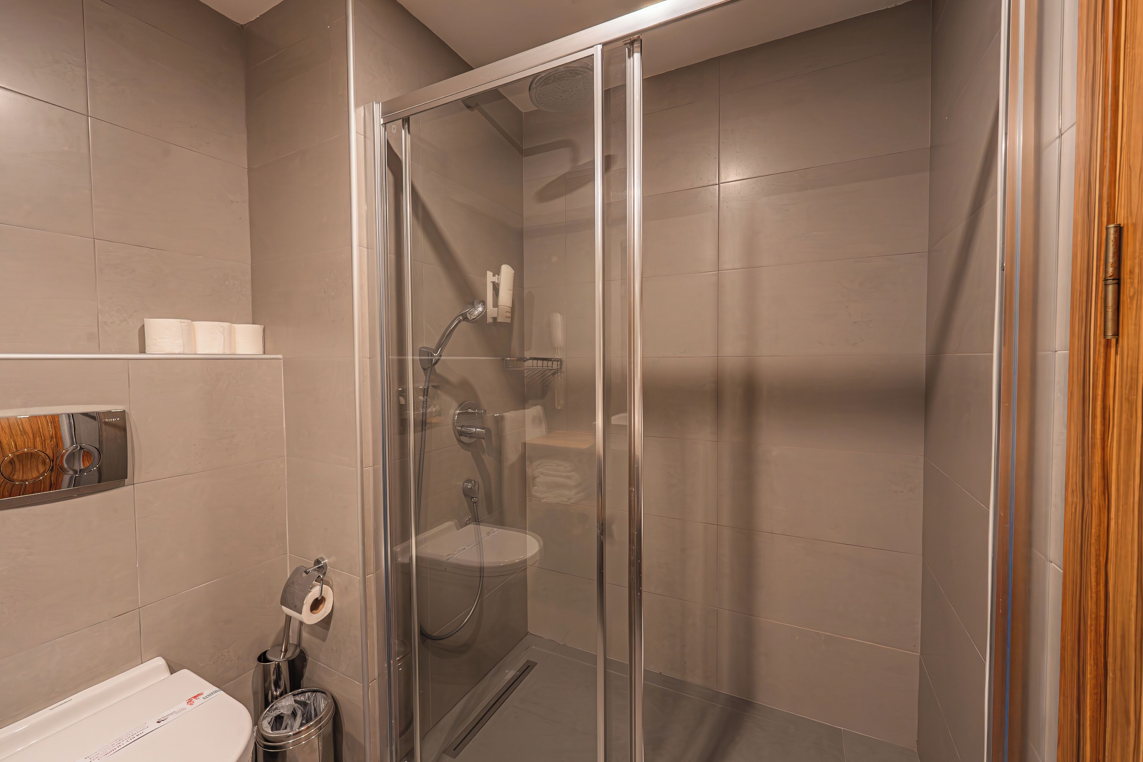 Un baño moderno con cabina de ducha de vidrio, inodoro y lavabo.