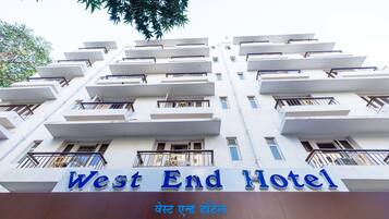 The exterior of the West End Hotel with a modern architectural design, featuring multiple balconies and a prominent sign.