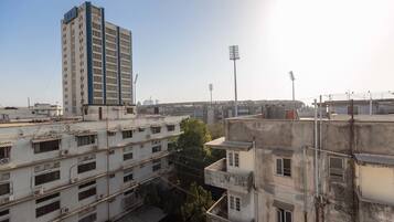 Un edificio de varios pisos con una torre central destacada, rodeado de otras construcciones residenciales.