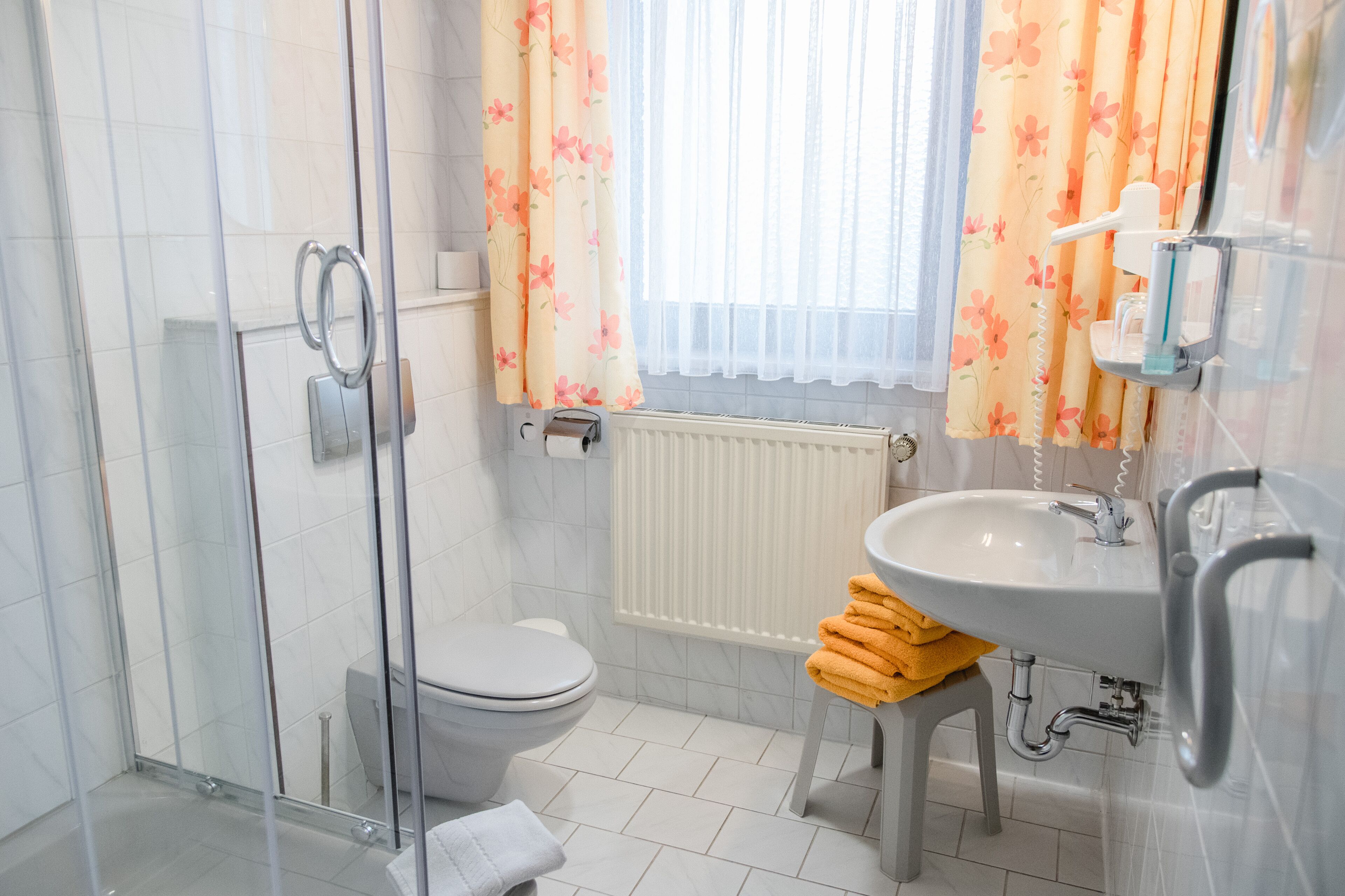 Une salle de bain équipée de toilettes, d’une douche, d’un lavabo et d’un porte-serviettes avec des serviettes.