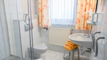 Une salle de bain équipée de toilettes, d’une douche, d’un lavabo et d’un porte-serviettes avec des serviettes.