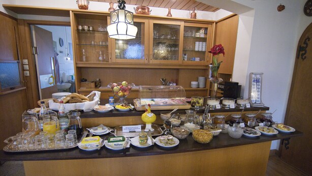 A buffet counter with various food items and beverages.