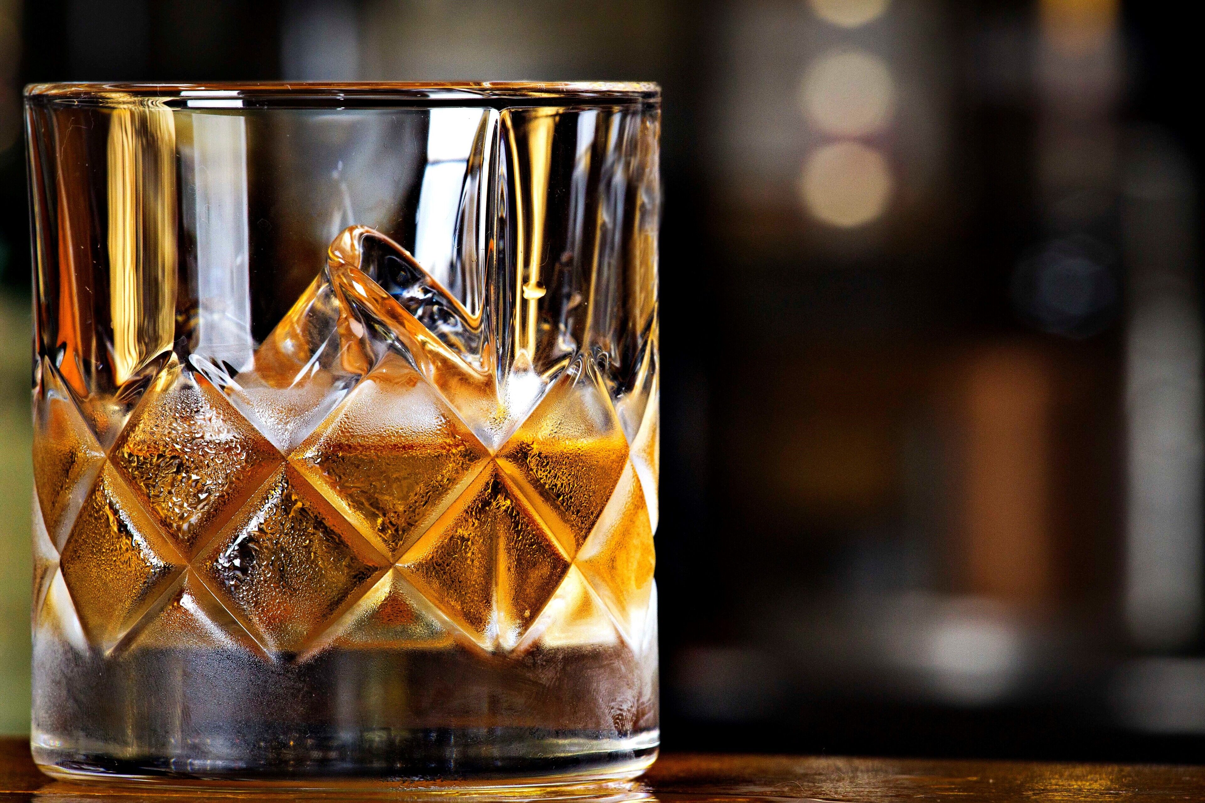 Un vaso transparente con diseño de diamantes, conteniendo una bebida.