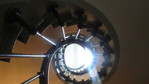 Una escalera de caracol con un candelabro en el centro.