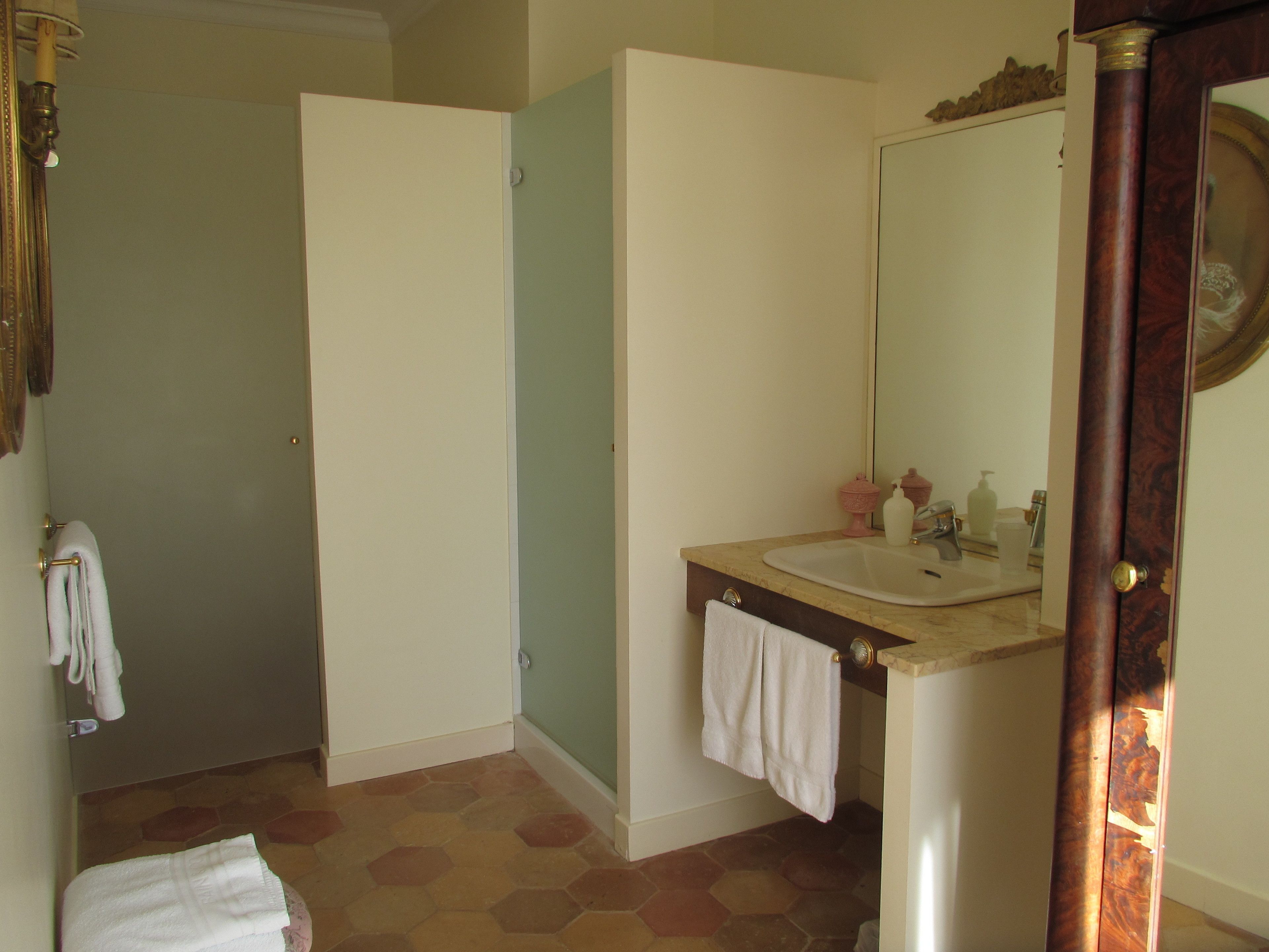 A bathroom with a sink, mirror, and a towel rack.