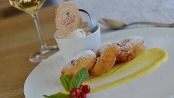 En desserttallerken med flormelisdrys, en isbolle og en lille kop med en kiks.
