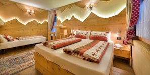 Ein gemütlicher Holzraum mit einem Bett, einem kleinen Tisch und einem Nachttisch.