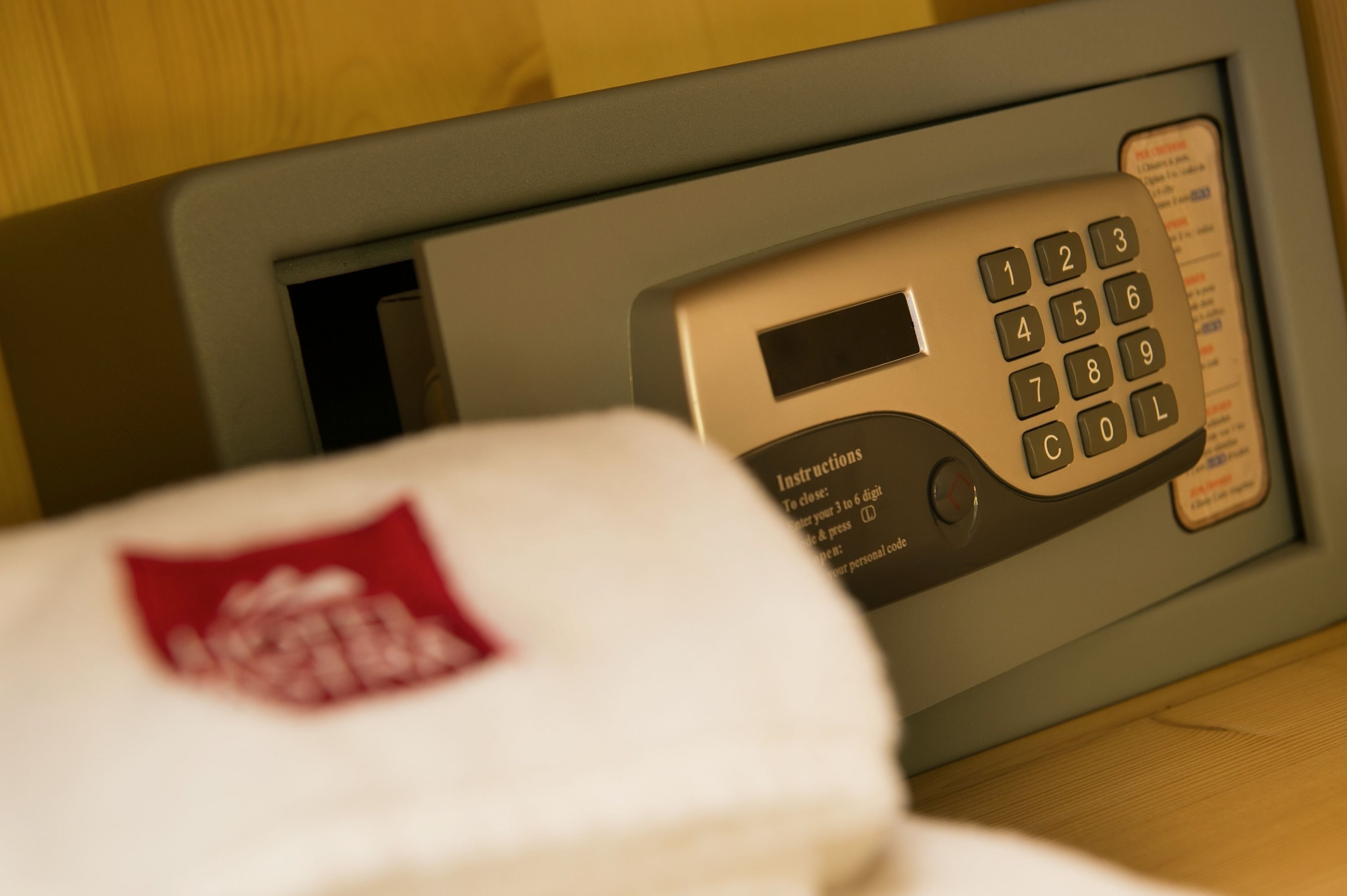A close-up of a room's control panel with a keypad and a small screen.