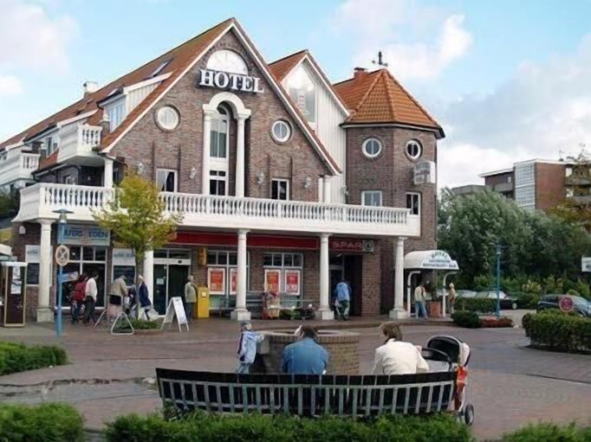 A hotel with a prominent 'HOTEL' sign, a balcony, and a storefront with a 'SPAR' sign.