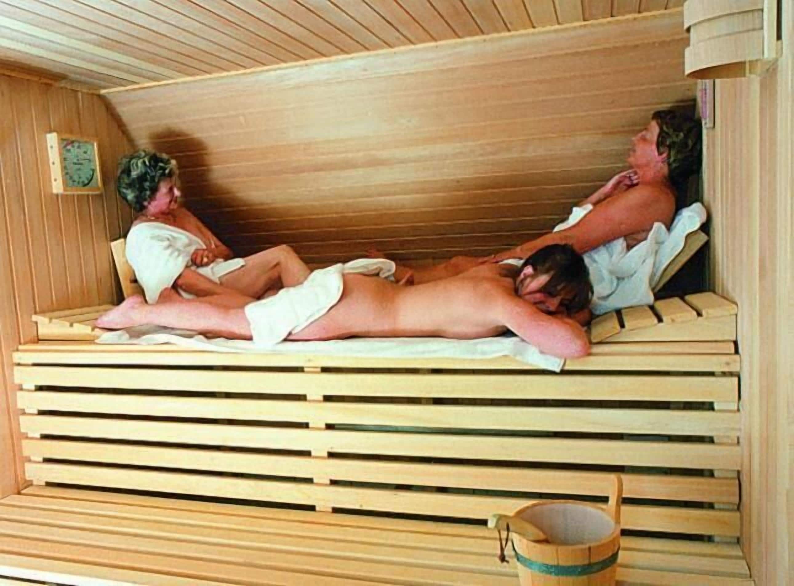 Un sauna avec des bancs en bois et un seau.