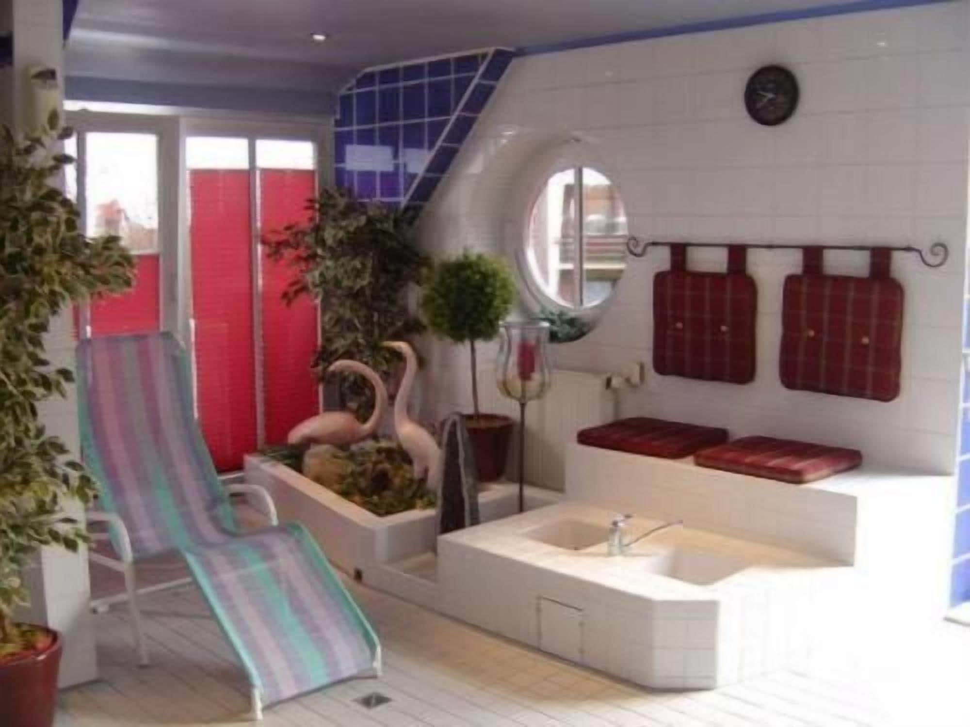 A bathroom with a bathtub, a shower, and a small seating area with a slide.