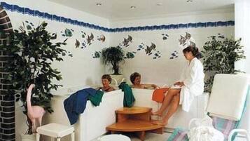 Relax in this serene space with a bathtub, two comfortable chairs, and a small table.