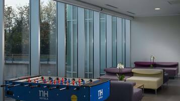 Relax in our stylish lobby, featuring a large foosball table and comfortable seating areas with a view of the outdoors.