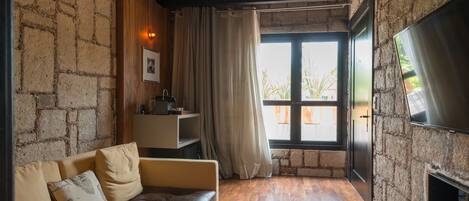 Un salón acogedor con un sofá de cuero, una mesa de centro de madera y una pared de piedra.