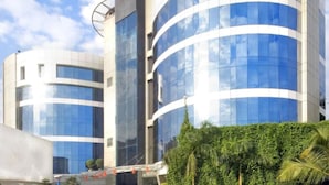 A modern building with curved glass facades and a circular structure. - Peninsula Grand Hotel (Mumbai)