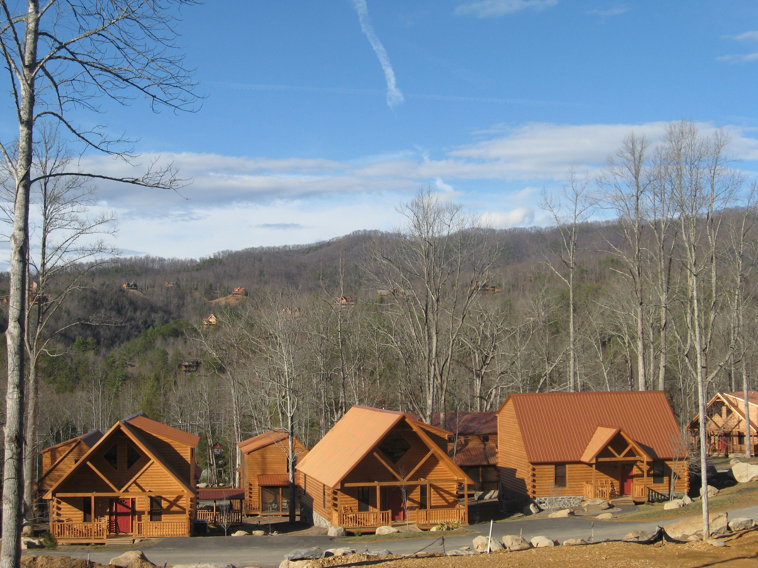 Eine Reihe von Blockhütten mit einer Holzterrasse und Bergblick.