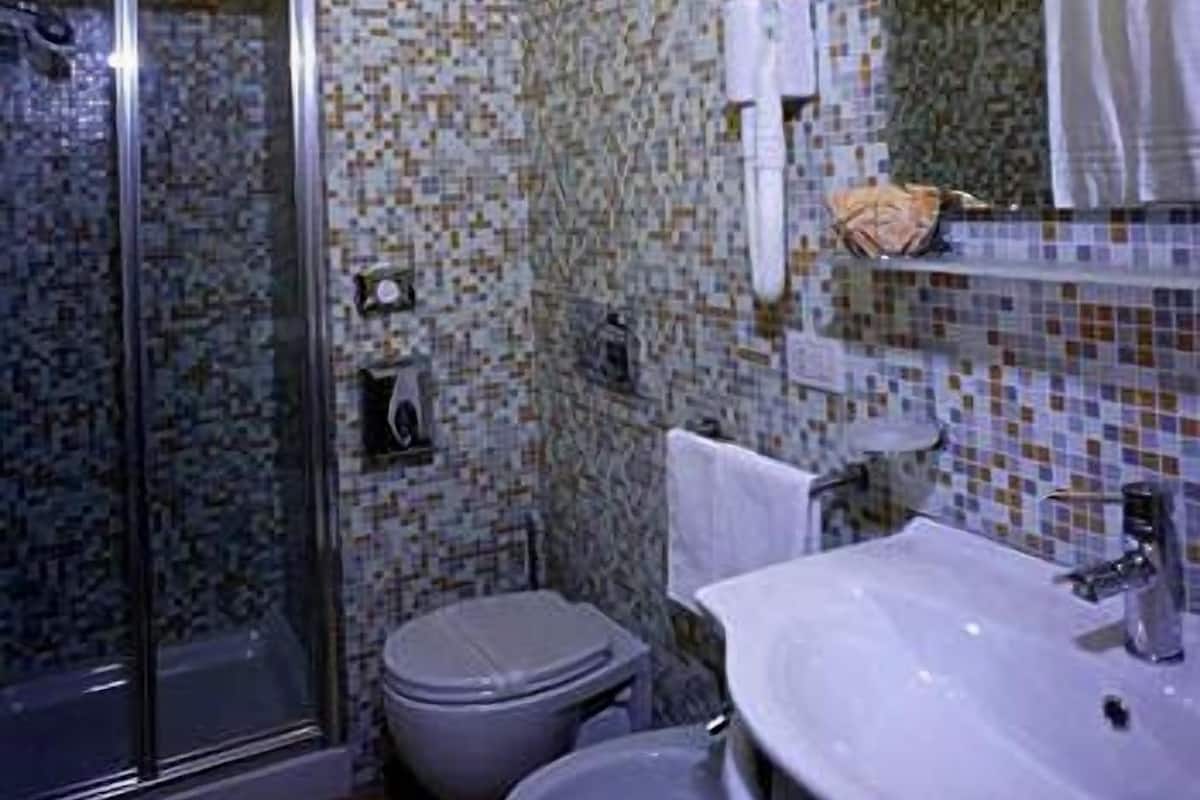 Un baño con ducha, inodoro y lavamanos.