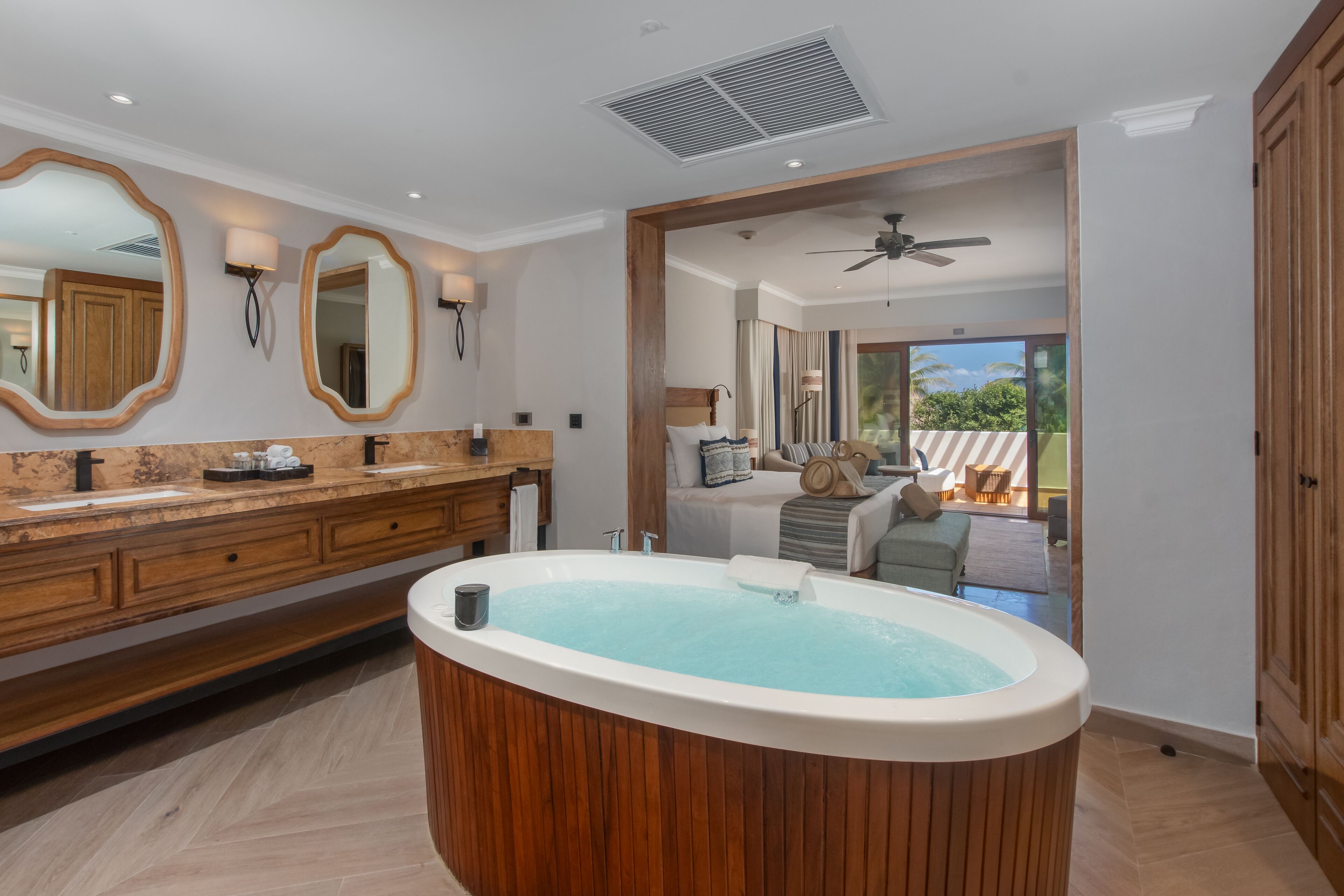 A modern bathroom with a wooden vanity, a freestanding bathtub, and a large mirror.