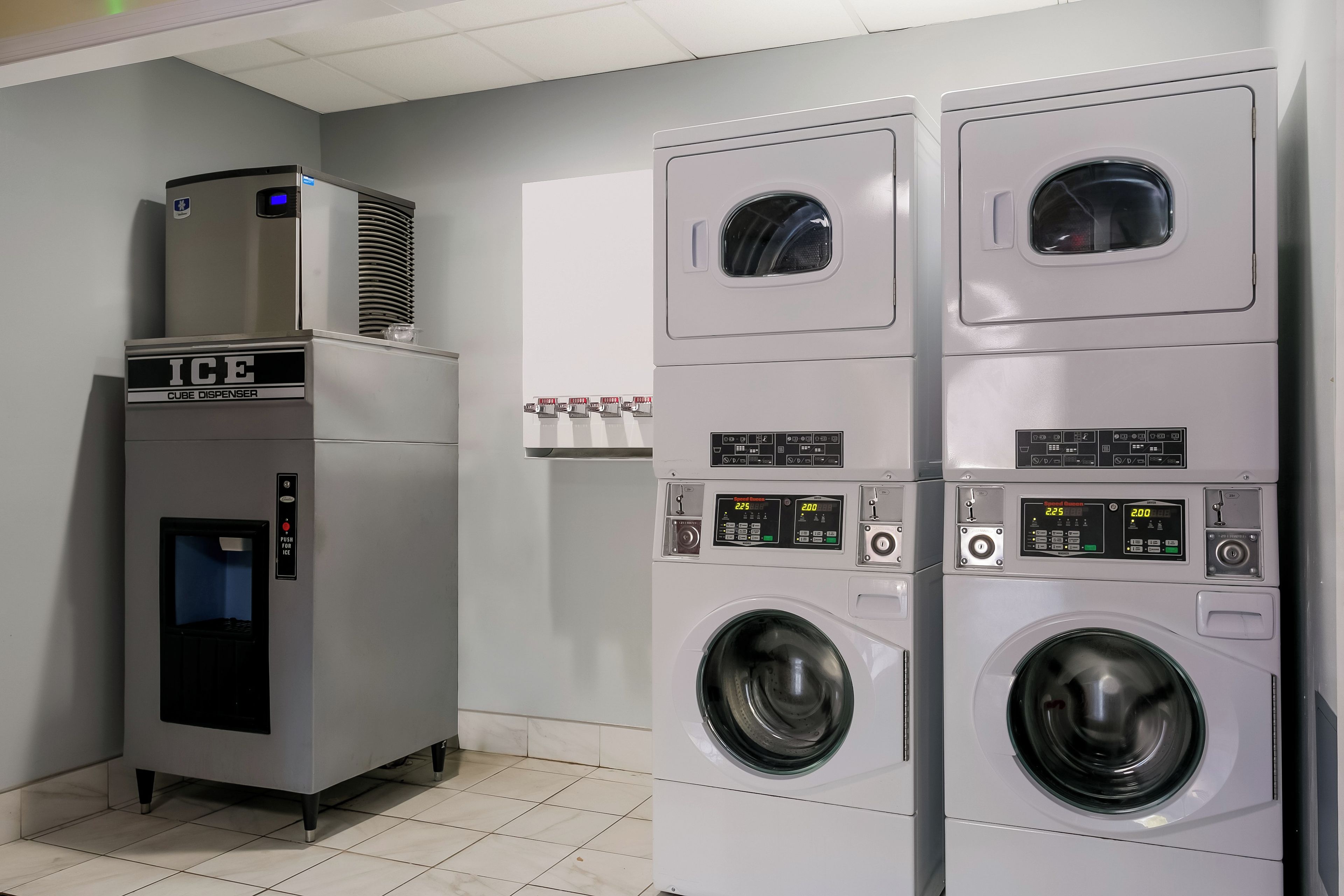 A laundry facility with a cube dispenser and stacked washing machines.