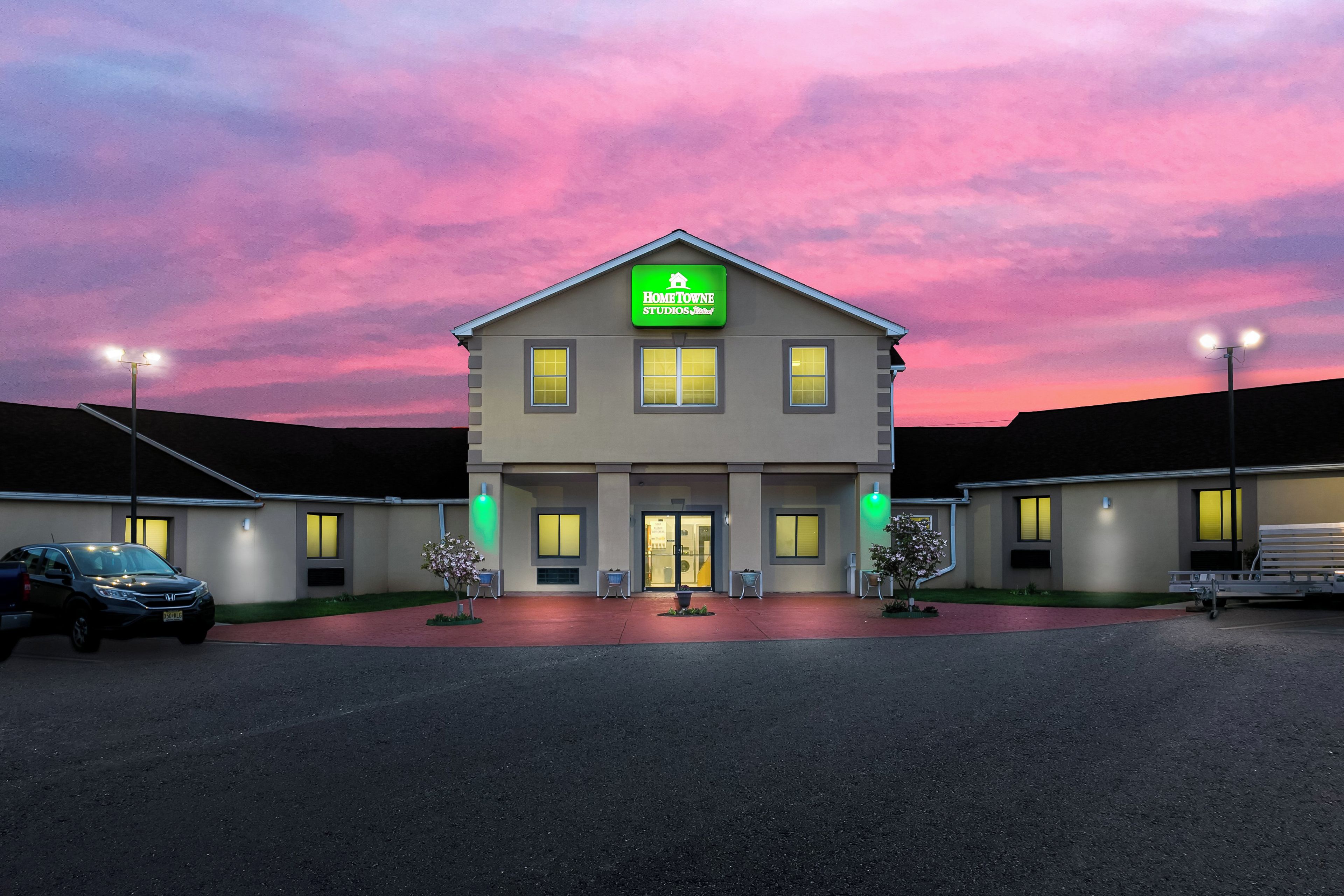 A two-story building with a sign reading 'HomeTowne Studios & Retreat' and a parking lot in front.