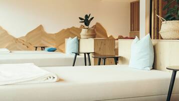 Relax in a serene space with a sofa, table, and plant, surrounded by a unique mountain-inspired wall feature and a window with a view.