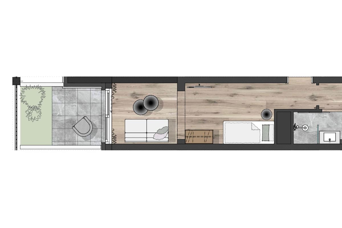 A floor plan of a hotel room with a bathroom, a kitchenette, a seating area, and a small garden view.
