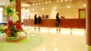 A hotel reception area with a modern design, featuring a reception desk and a large floral arrangement. - Evenia Olympic Palace (Lloret de Mar)