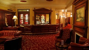 A lobby with a bar area, leather seating, and a fireplace.