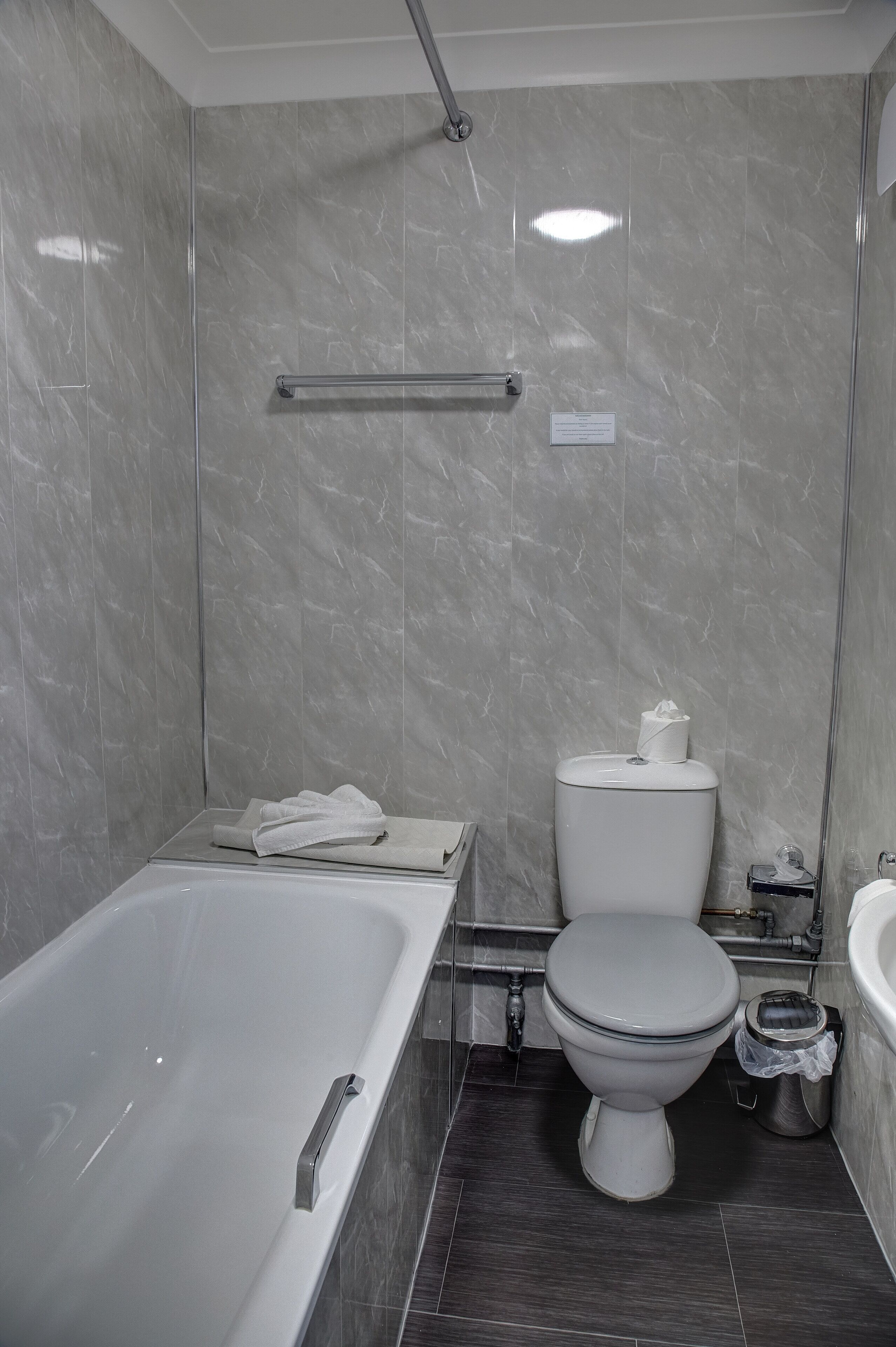 A modern bathroom with a bathtub, toilet, and sink.