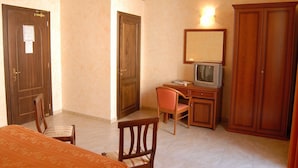 A hotel room with a bed, a desk with a television, a chair, and a wardrobe. - Hotel Gresi (Catania)