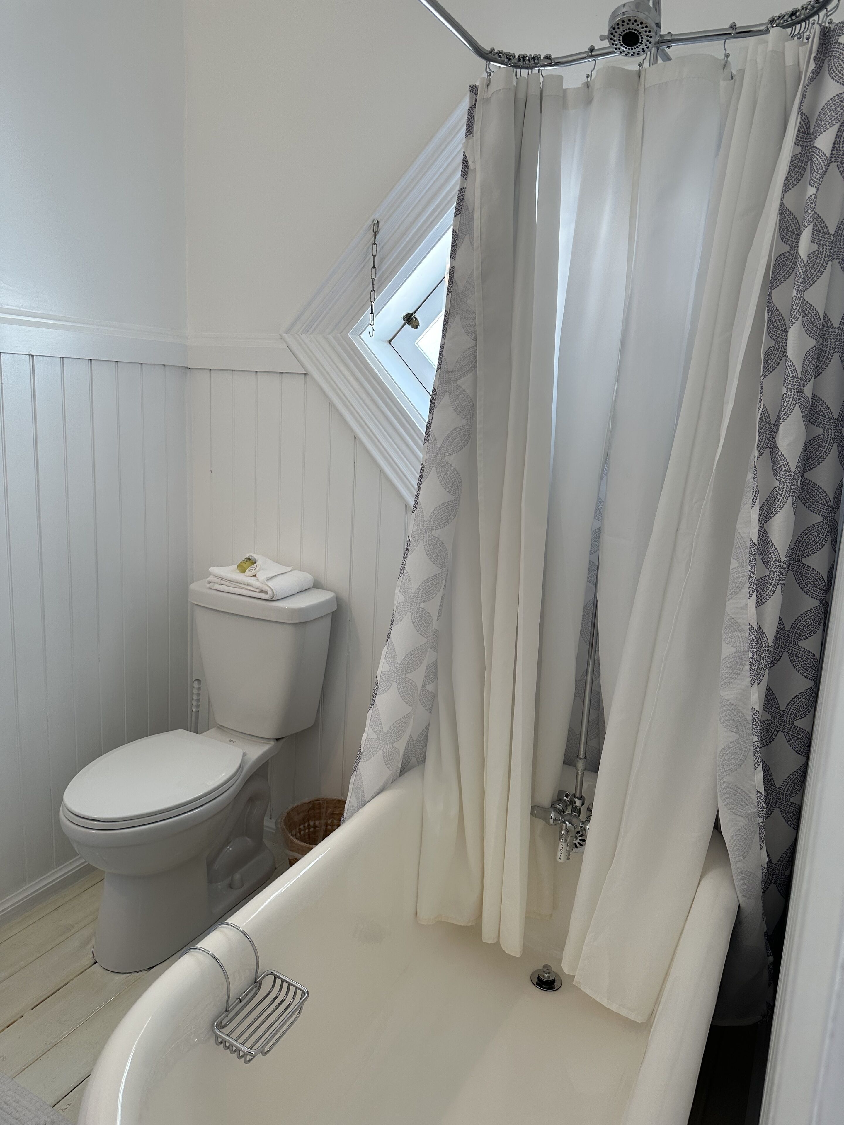 A bathroom with a toilet, a bathtub, and a shower curtain.