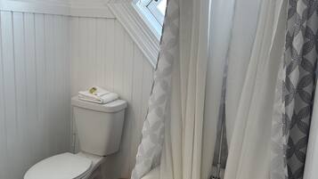 A bathroom with a toilet, a bathtub, and a shower curtain.