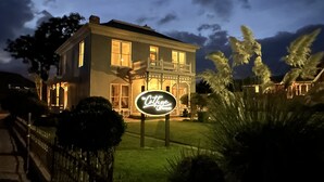 A two-story house with a balcony, a well-maintained lawn, and a sign that reads "Cottage". - The Cottage @ 241 North (St. George)
