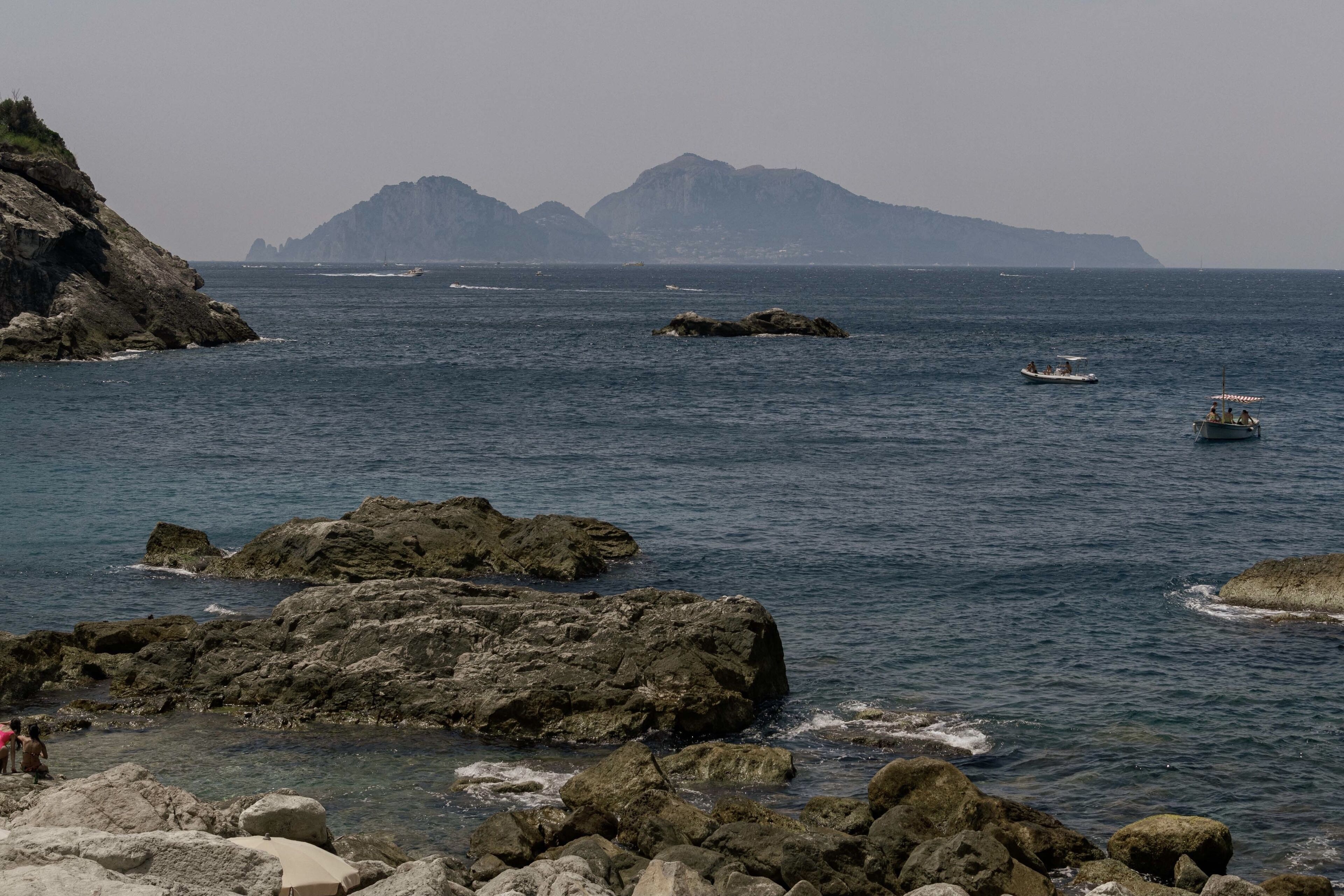A coastal scene with rocky terrain and calm waters.