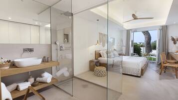 Ein modernes Schlafzimmer mit einem großen Bett, einer Dusche mit Glastrennwand und einem Balkon mit Blick.