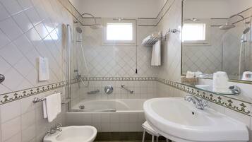 Un bagno moderno con vasca, lavandino e zona doccia.