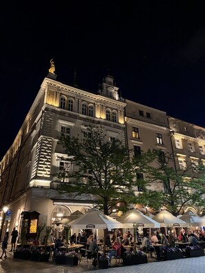 A historic building with ornate architecture, outdoor seating, and a well-lit facade. - The Bonerowski Palace Boutique Hotel (Kraków)