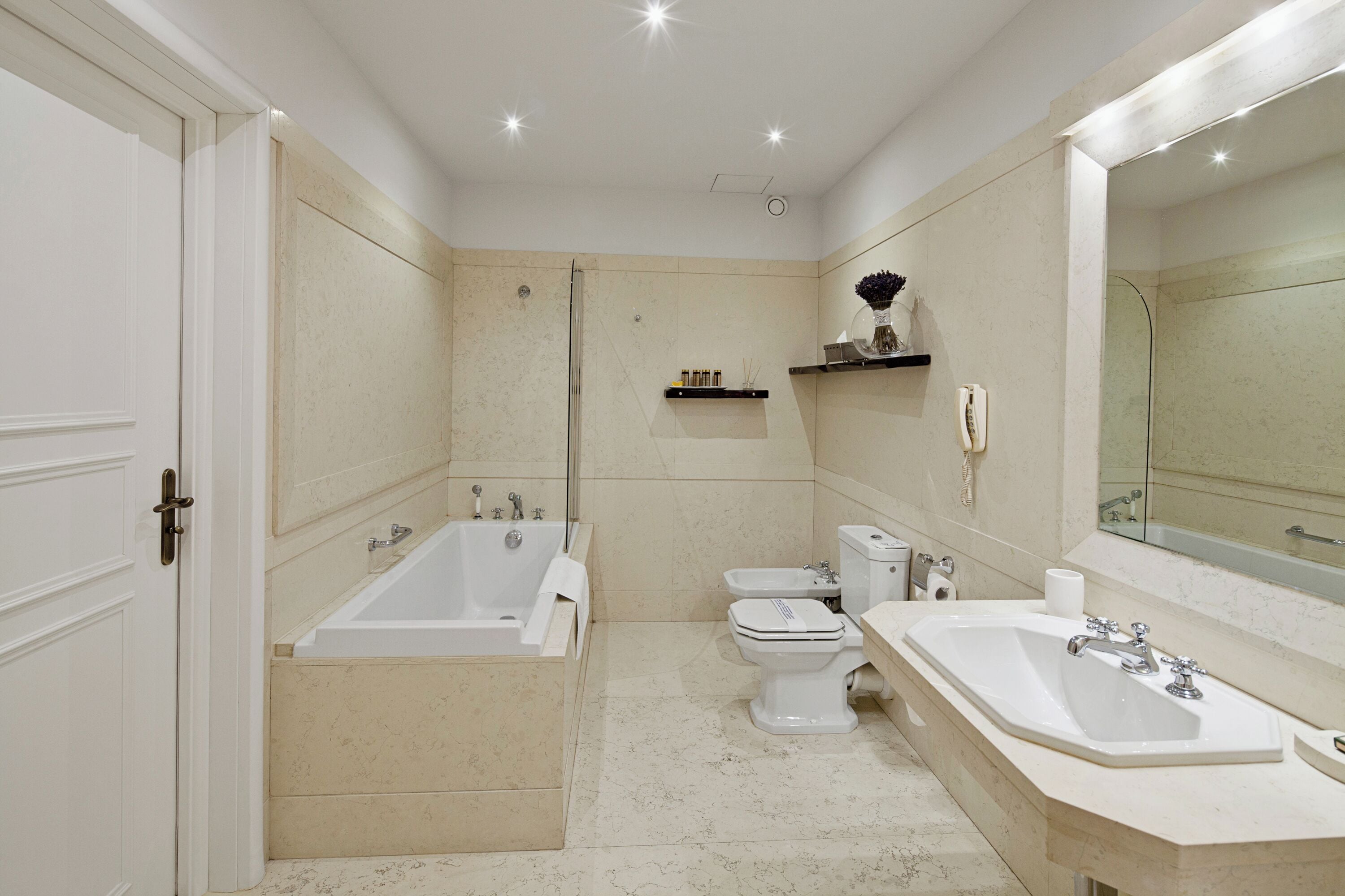 A bathroom with a bathtub, toilet, bidet, and sink.