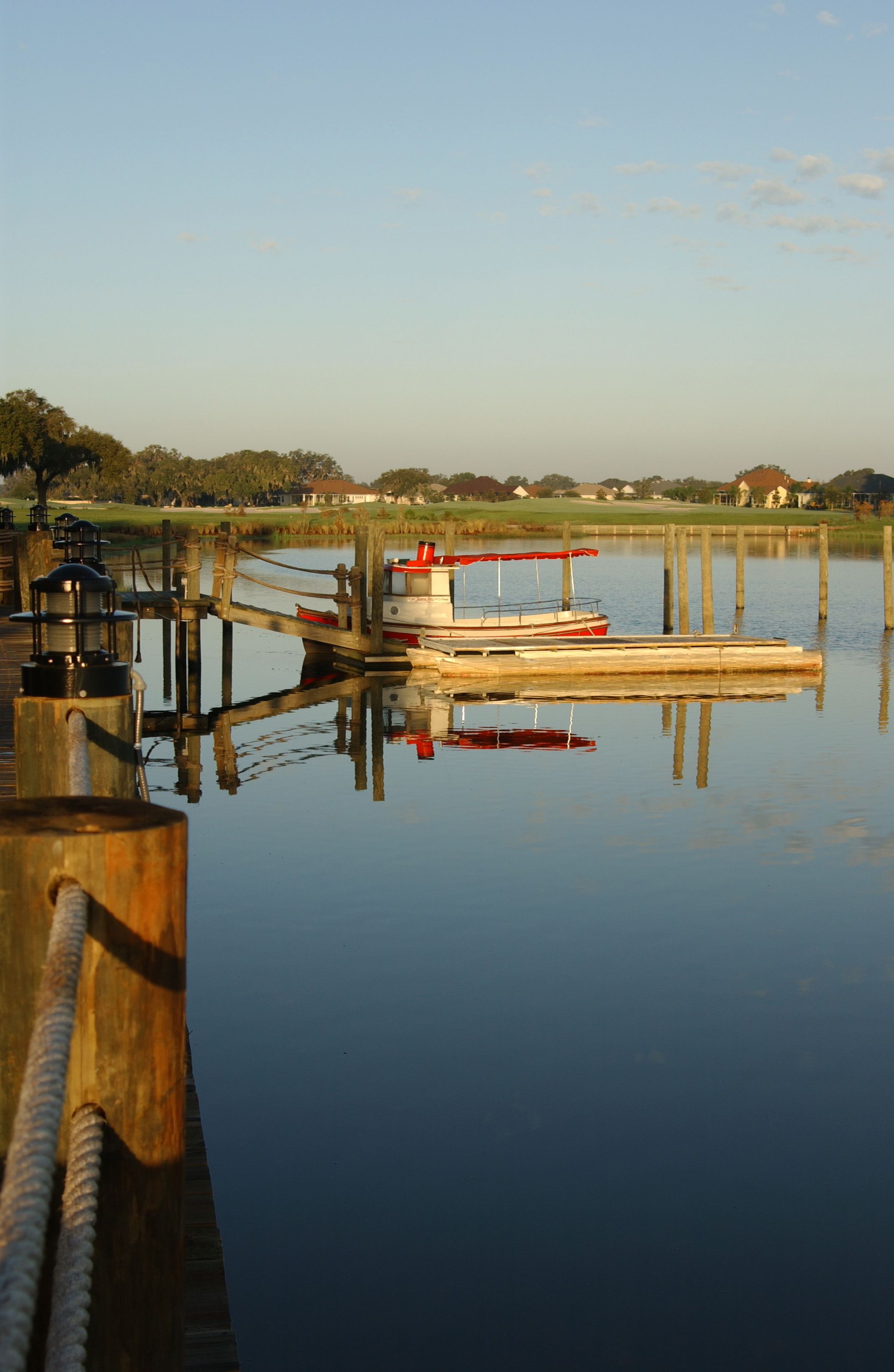 A calm lake with a dock and a boat.