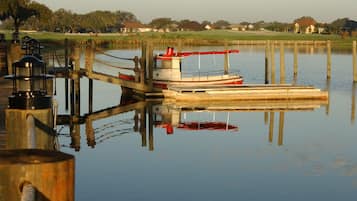 A calm lake with a dock and a boat.