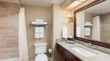 A bathroom with a toilet, sink, and shower curtain.