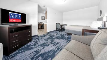Una habitación de hotel con televisión, cama, escritorio y silla.