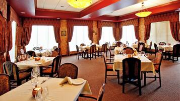 A restaurant with multiple tables set for dining, featuring a carpeted floor and classic decor.