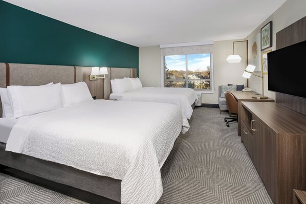 A hotel room with two beds, a desk, a TV, and a window with a view. - Holiday Inn Quincy East by IHG (Quincy)