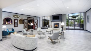 A spacious lobby with a fireplace, seating area, and large windows. - Holiday Inn Quincy East by IHG (Quincy)