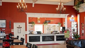 Un hall d’hôtel comprenant un comptoir d’accueil, un espace où l’on peut se servir du café et des coins salon.