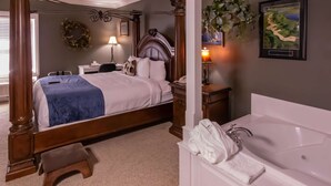 Une chambre à coucher avec un lit à baldaquin, une table de chevet avec une lampe, un bureau avec un téléphone et une salle de bain avec une baignoire et une plante suspendue.