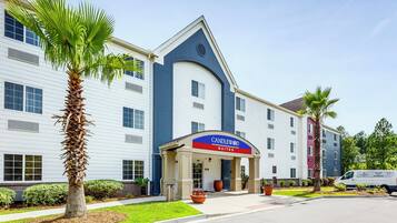 A hotel with a modern design, featuring a prominent entrance with a blue and red sign.