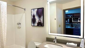 Une salle de bain avec une baignoire, des toilettes, un lavabo et un grand miroir.