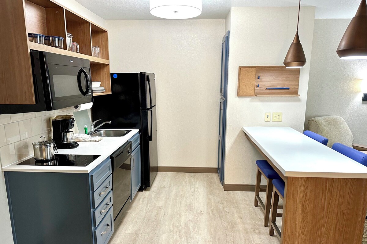 Una cocina compacta equipada con microondas, refrigerador y cafetera.